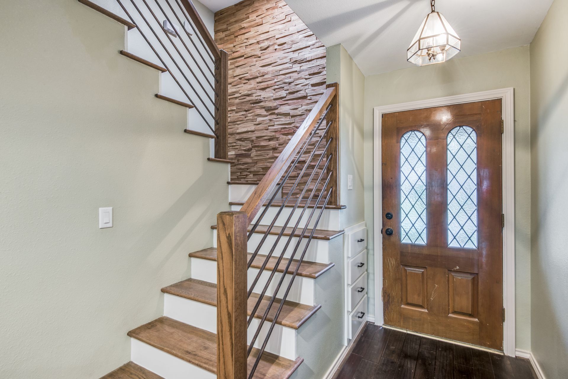 A wooden staircase leading up to a wooden door in a hallway.
