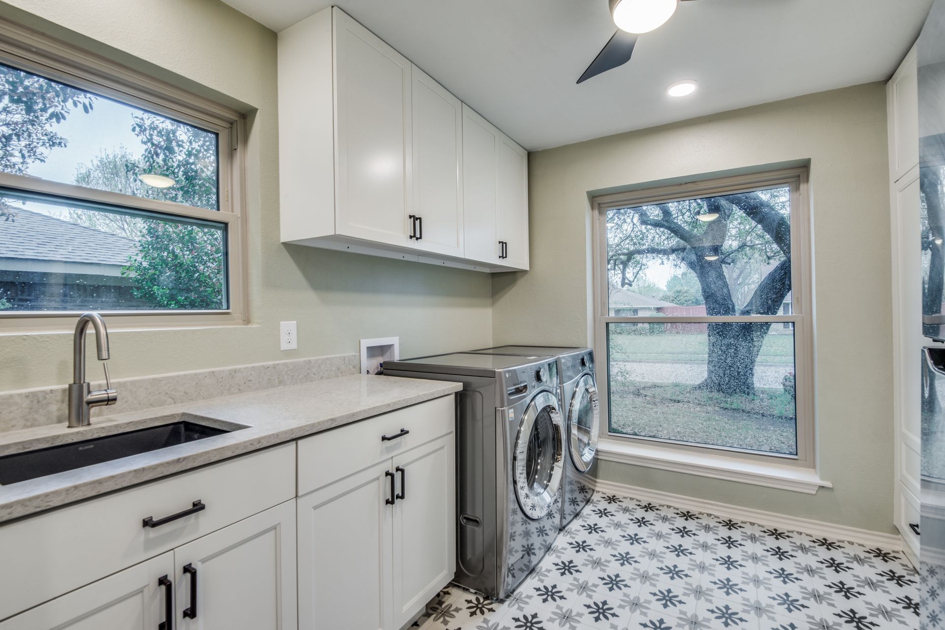 A laundry room with a washer and dryer , sink , and window.