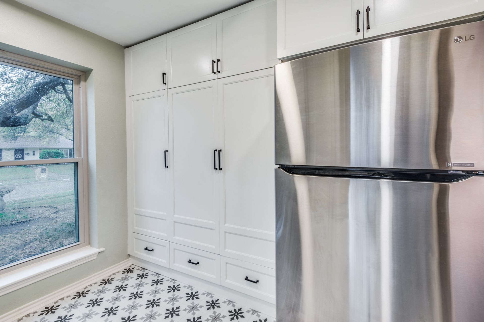 A kitchen with stainless steel appliances and white cabinets.