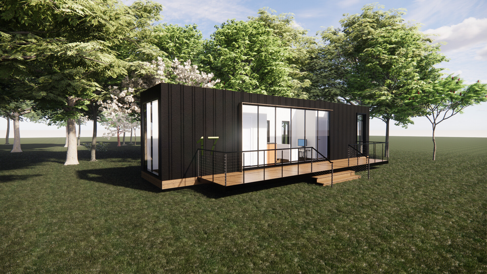 A small shipping container house is sitting in the middle of a grassy field surrounded by trees.