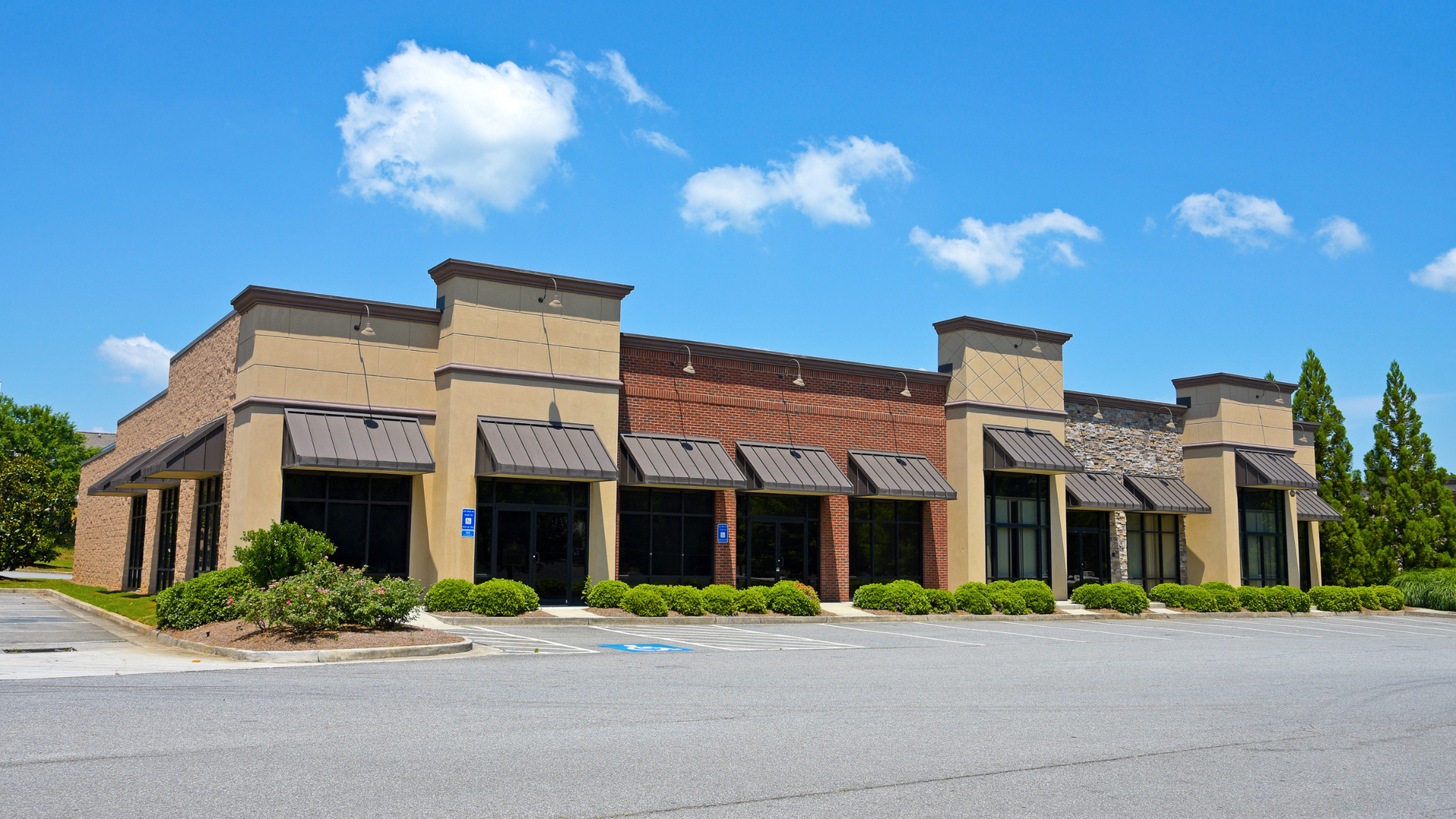 Building with awnings and a corrugated metal roof against a blue sky.