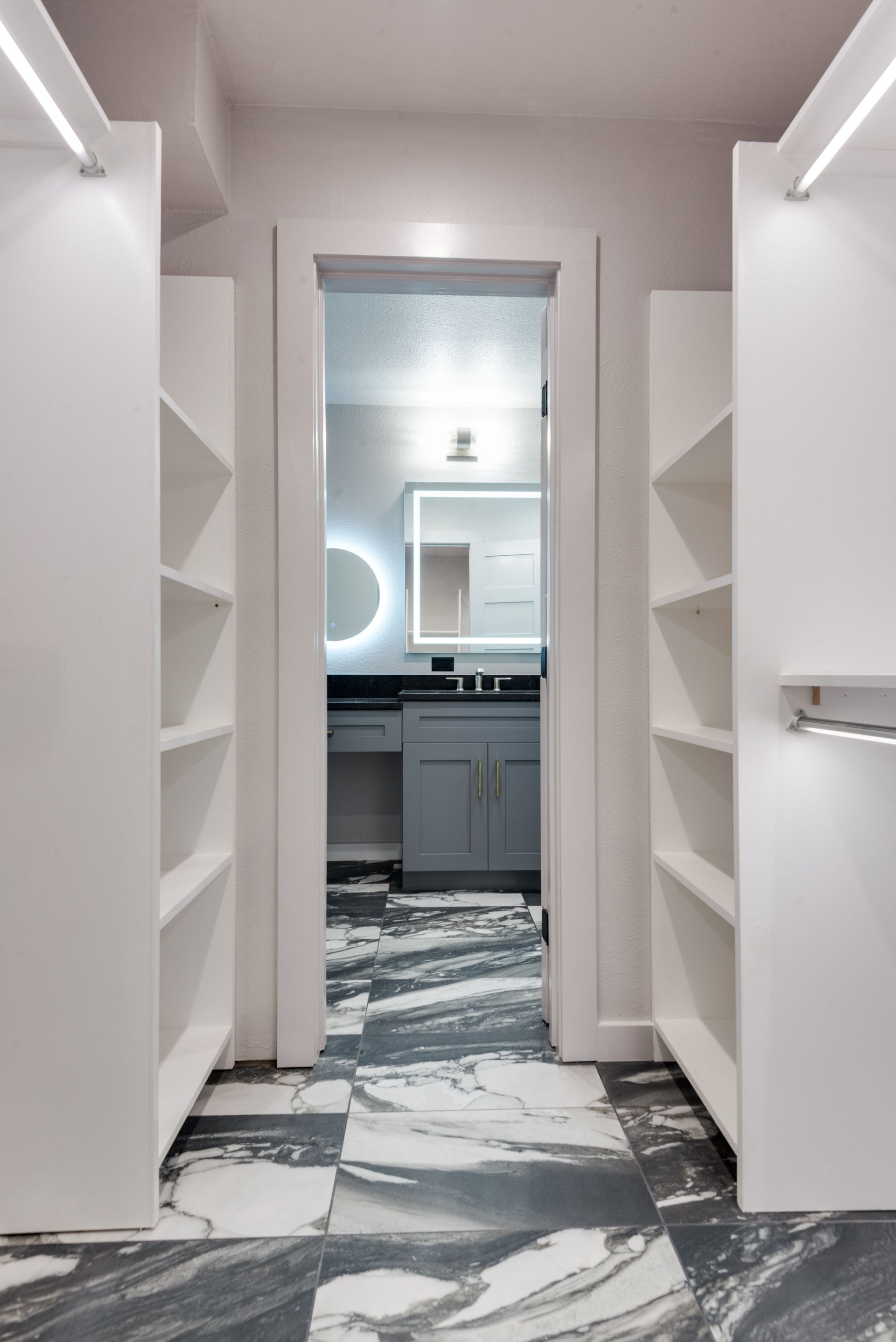 A walk in closet with a bathroom remodel in the background
