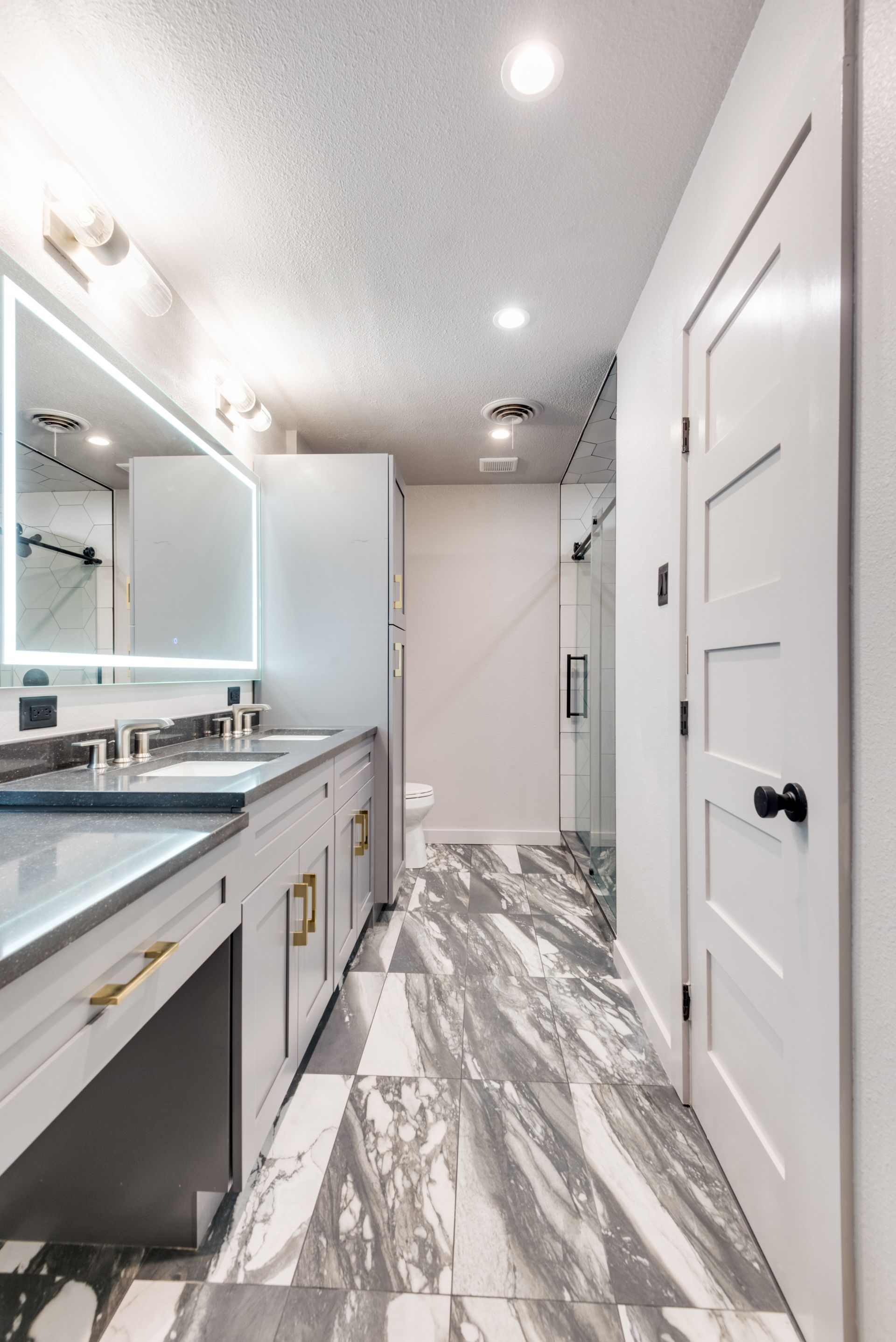 A bathroom remodel with two sinks and a large mirror