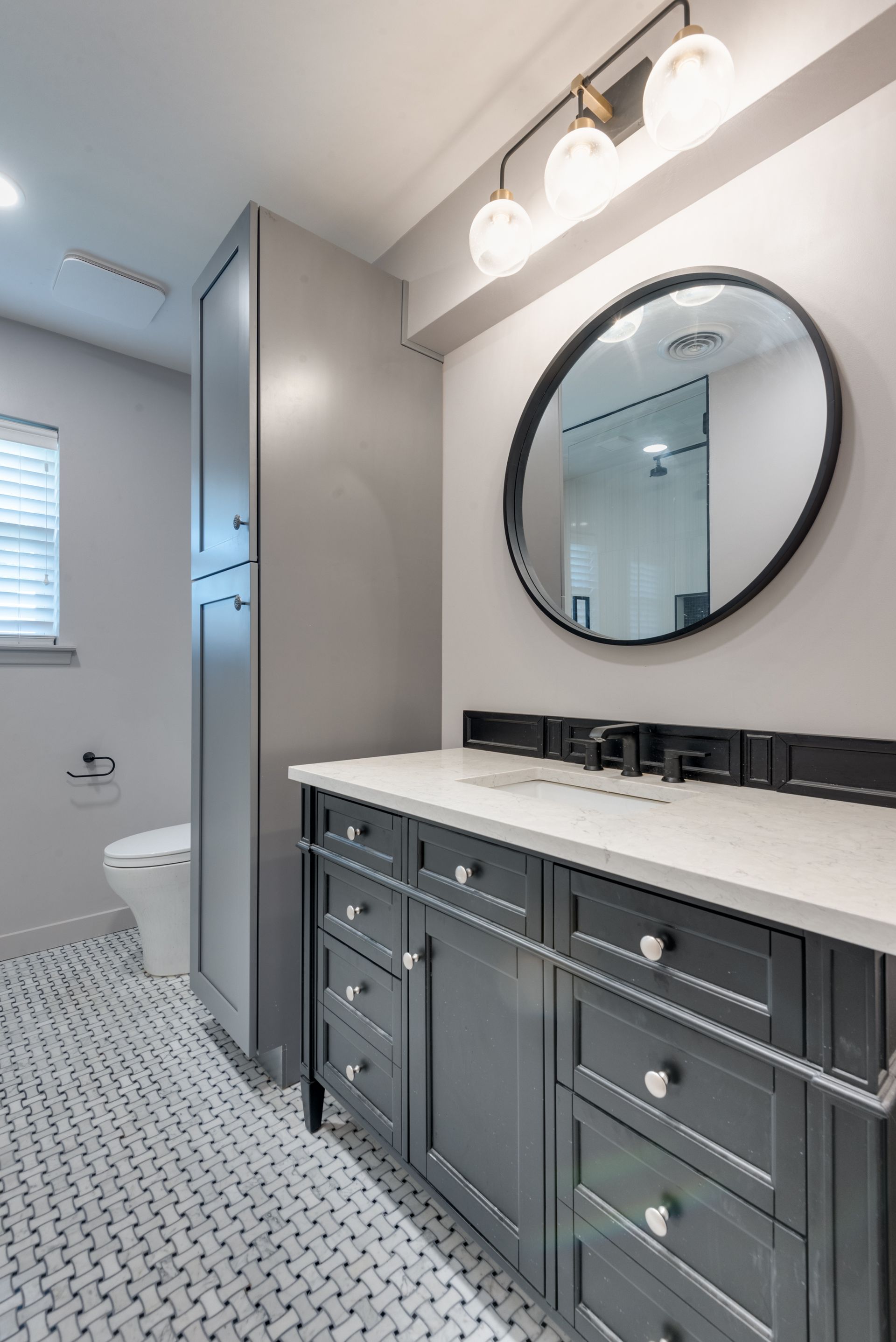 A bathroom remodel with a sink , mirror and toilet.