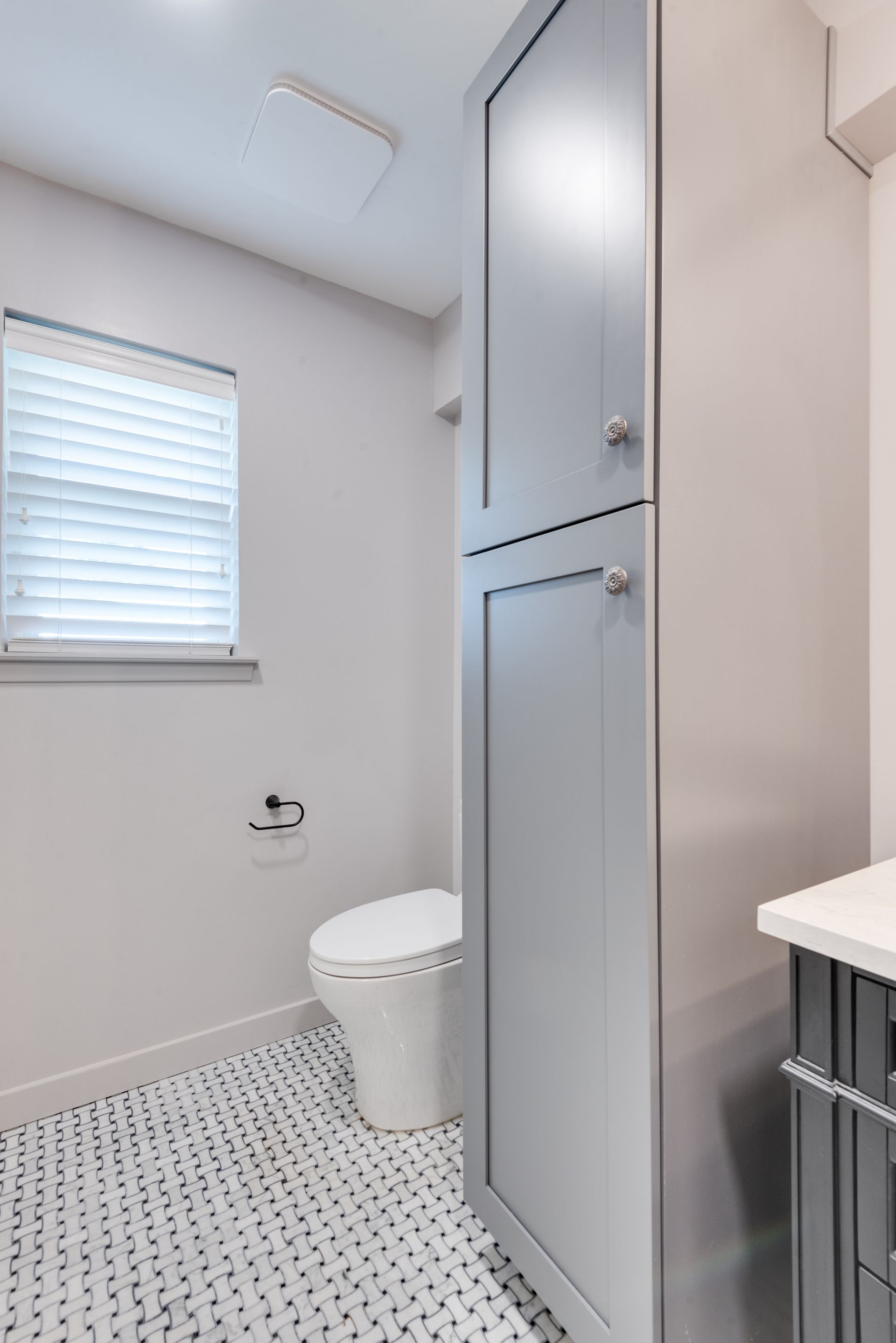 A bathroom remodel with a toilet , sink and window.