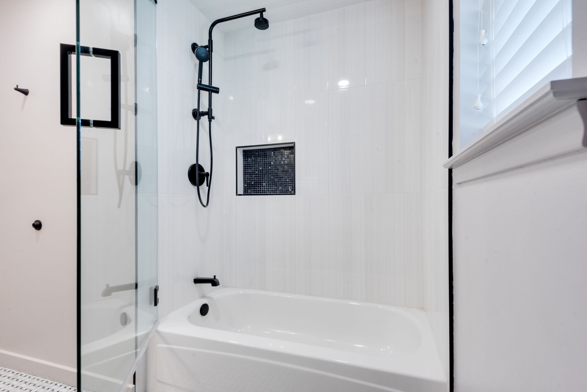 A bathroom remodel with a tub , shower , and window.
