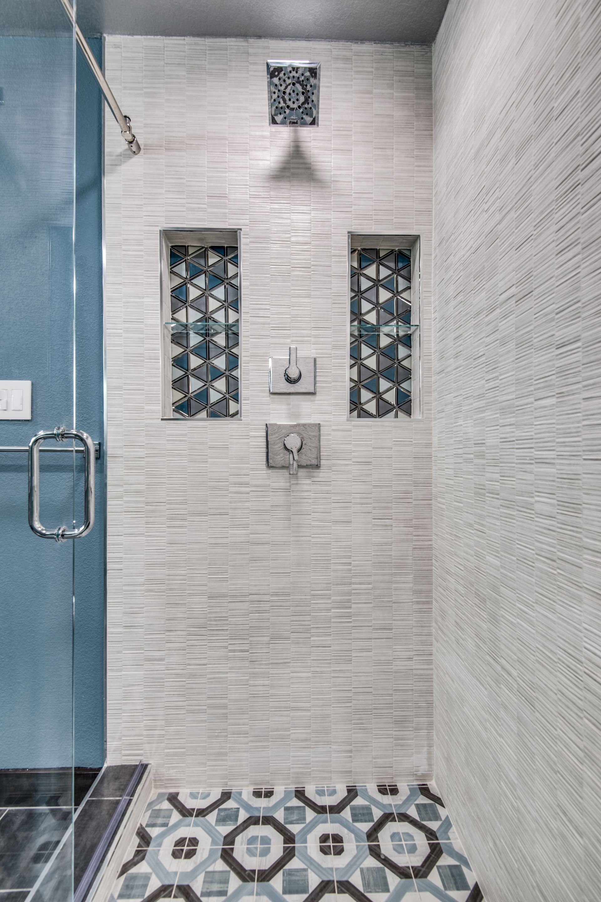 A bathroom remodel with a walk in shower and a tiled floor.