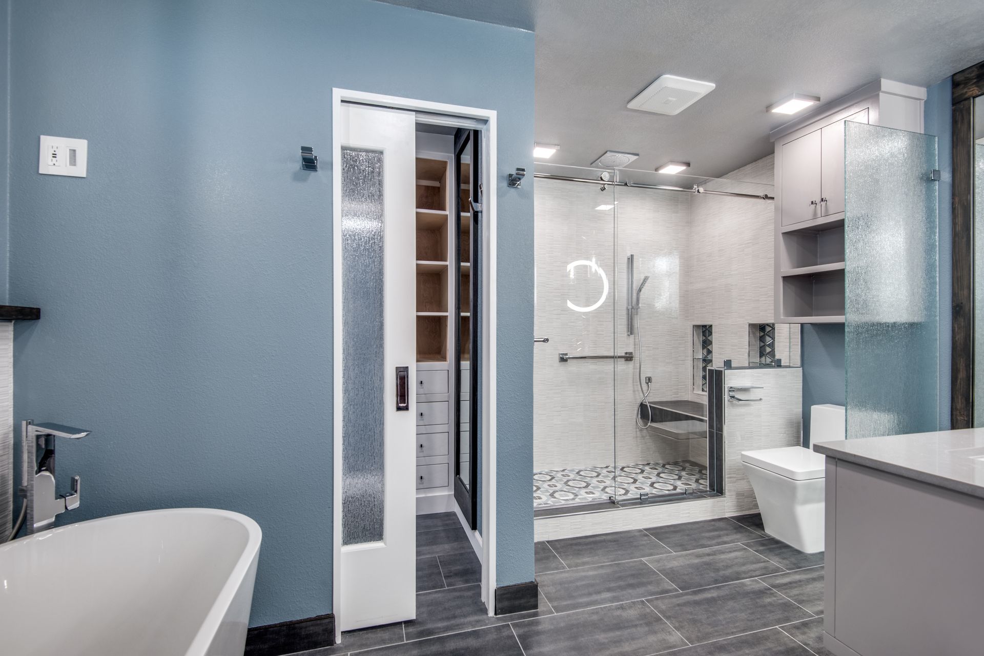 A bathroom remodel with a bathtub , toilet , shower and walk in closet.