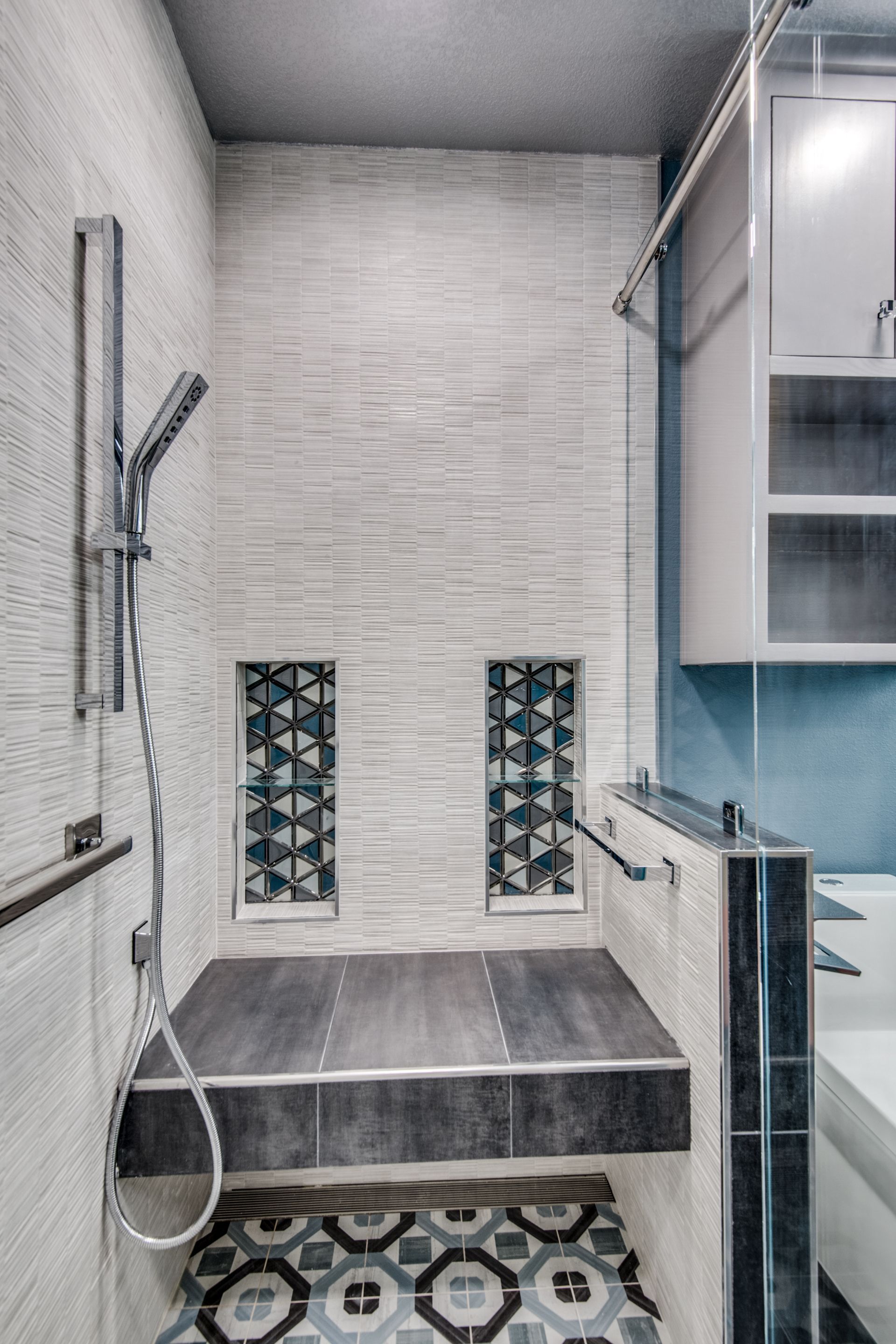A bathroom remodel with a walk in shower and a sink.