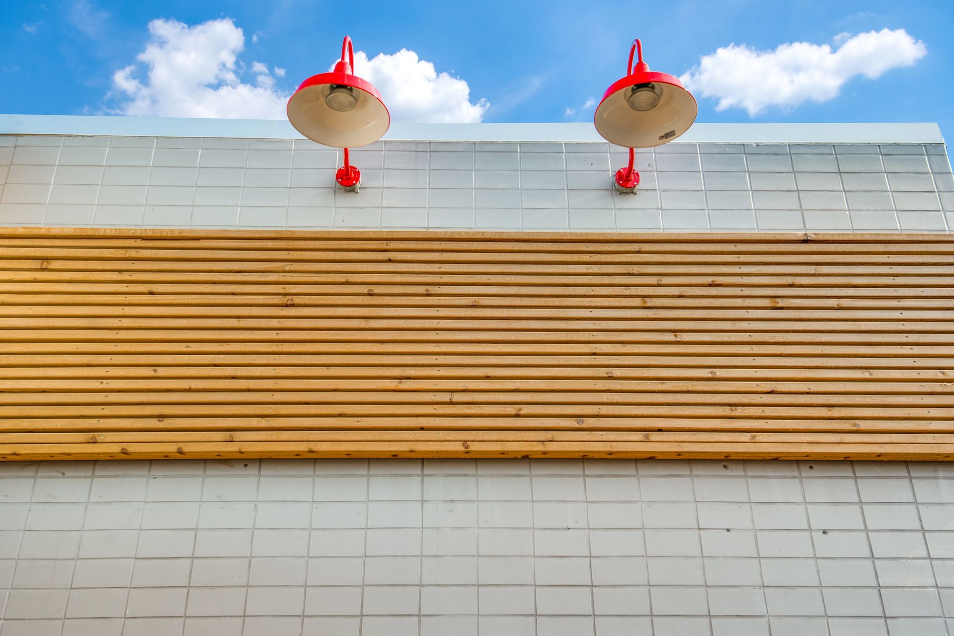There are two red lights on the side of a building.
