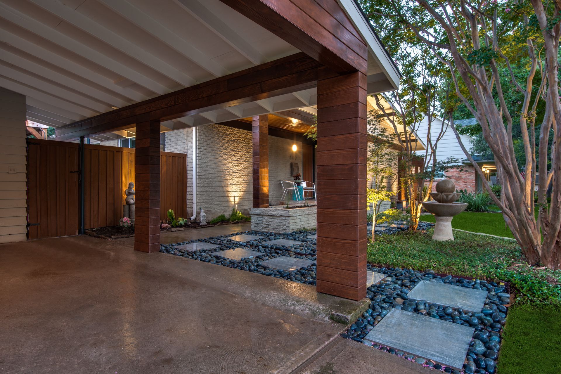 A house with a covered driveway and a walkway leading to it.