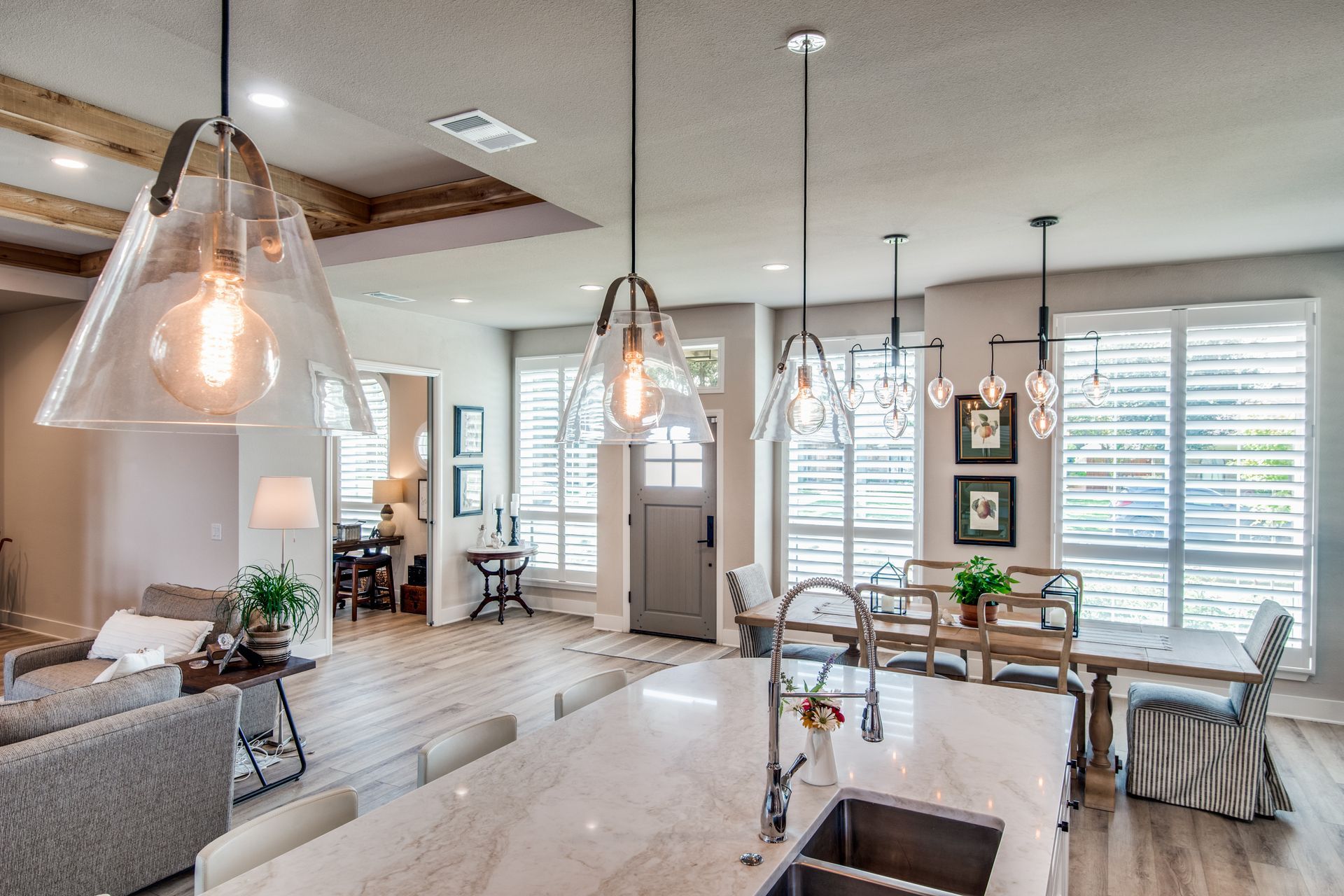 A kitchen with a sink and a dining room in the background.