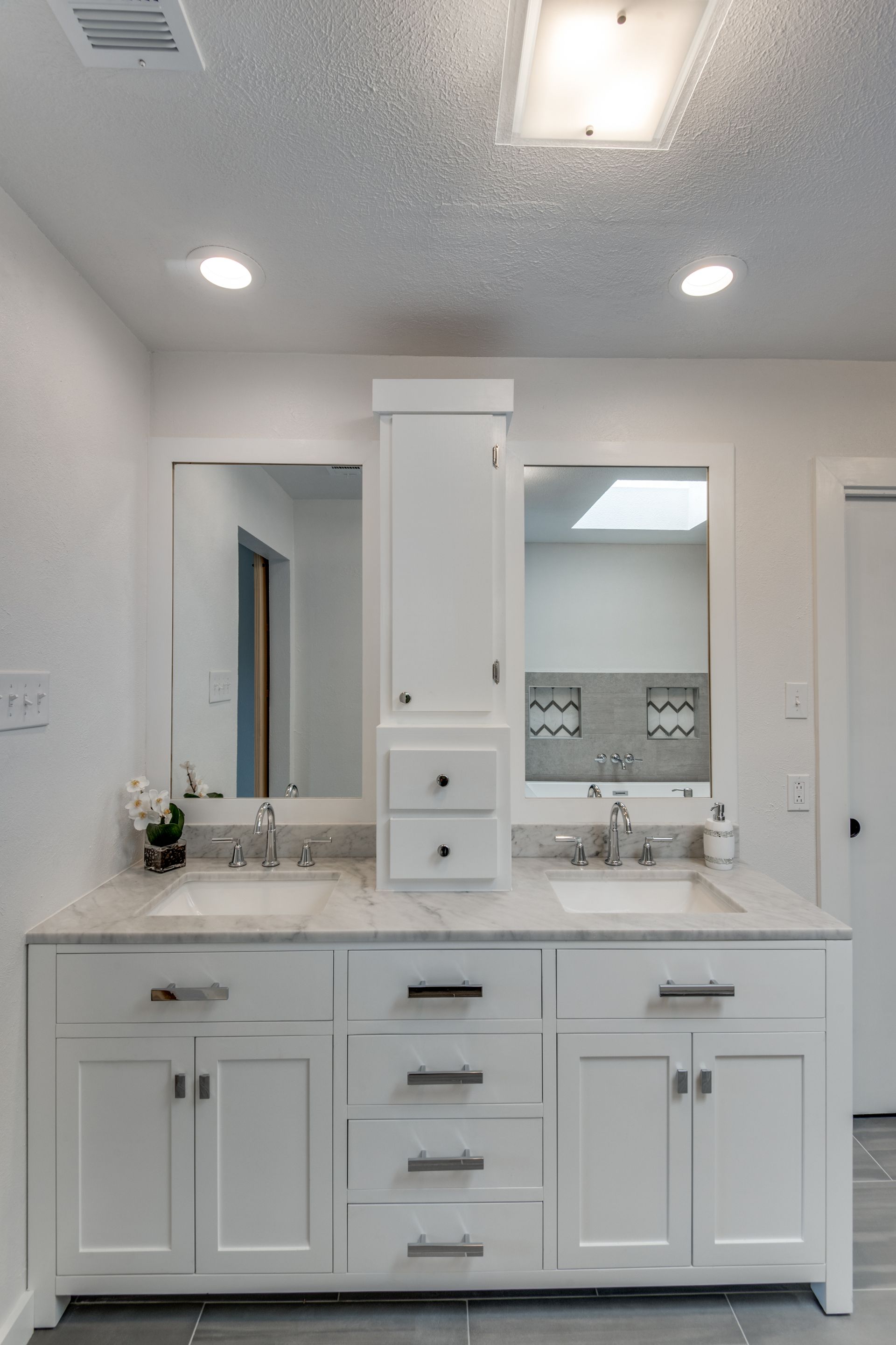 A bathroom remodel with two sinks and two mirrors.