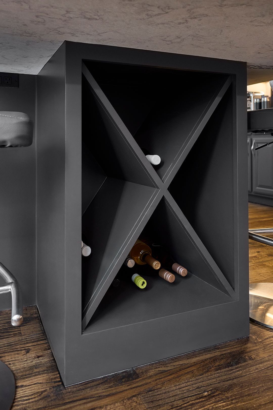 A wine rack with four bottles of wine in it.