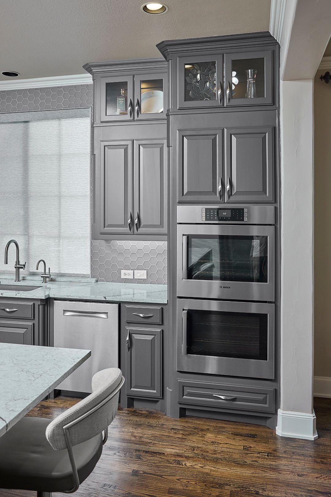 A kitchen with gray cabinets and stainless steel appliances