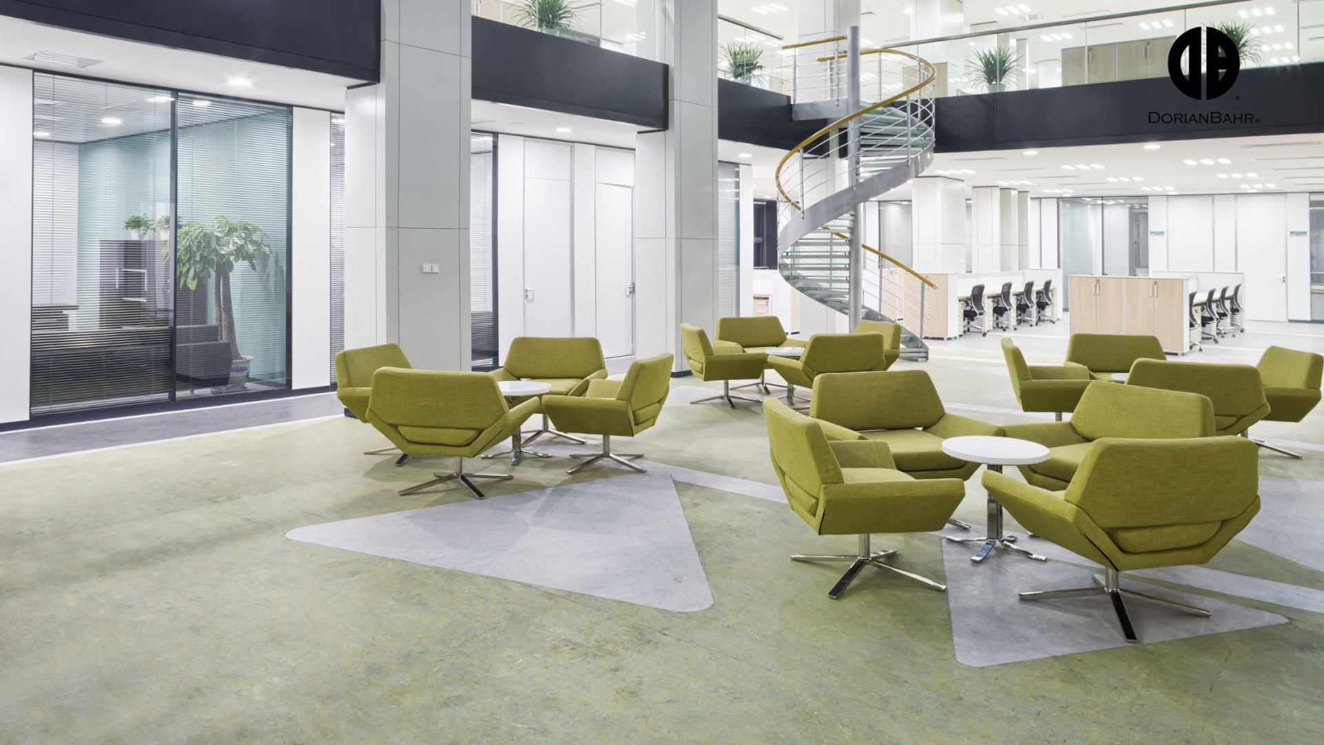 A lobby with green chairs and tables and a spiral staircase.