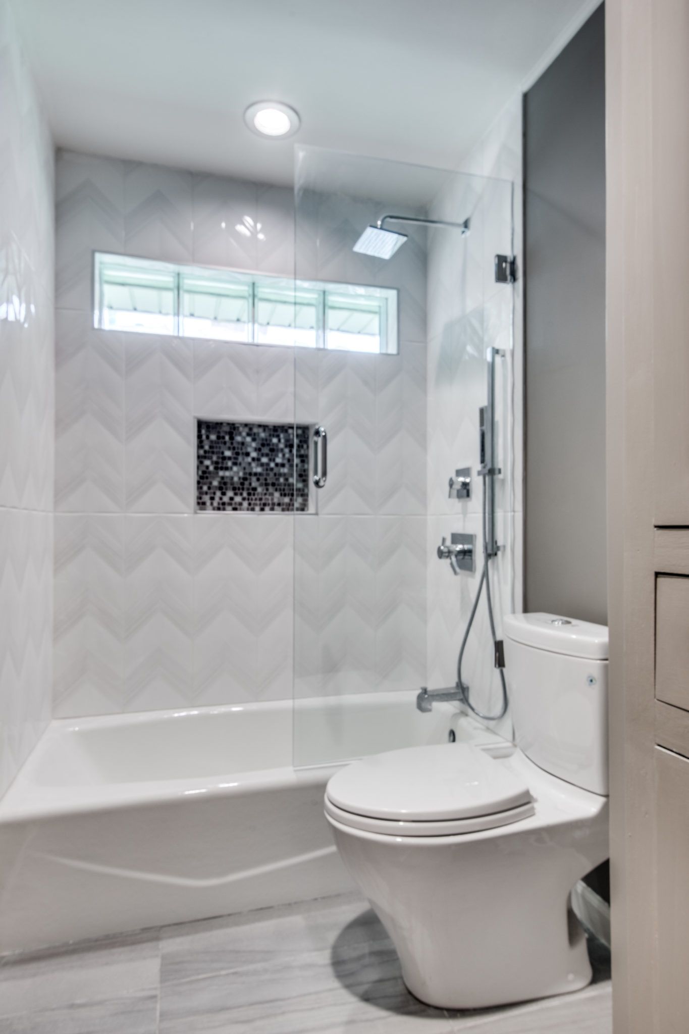 A bathroom with a toilet , tub and shower.