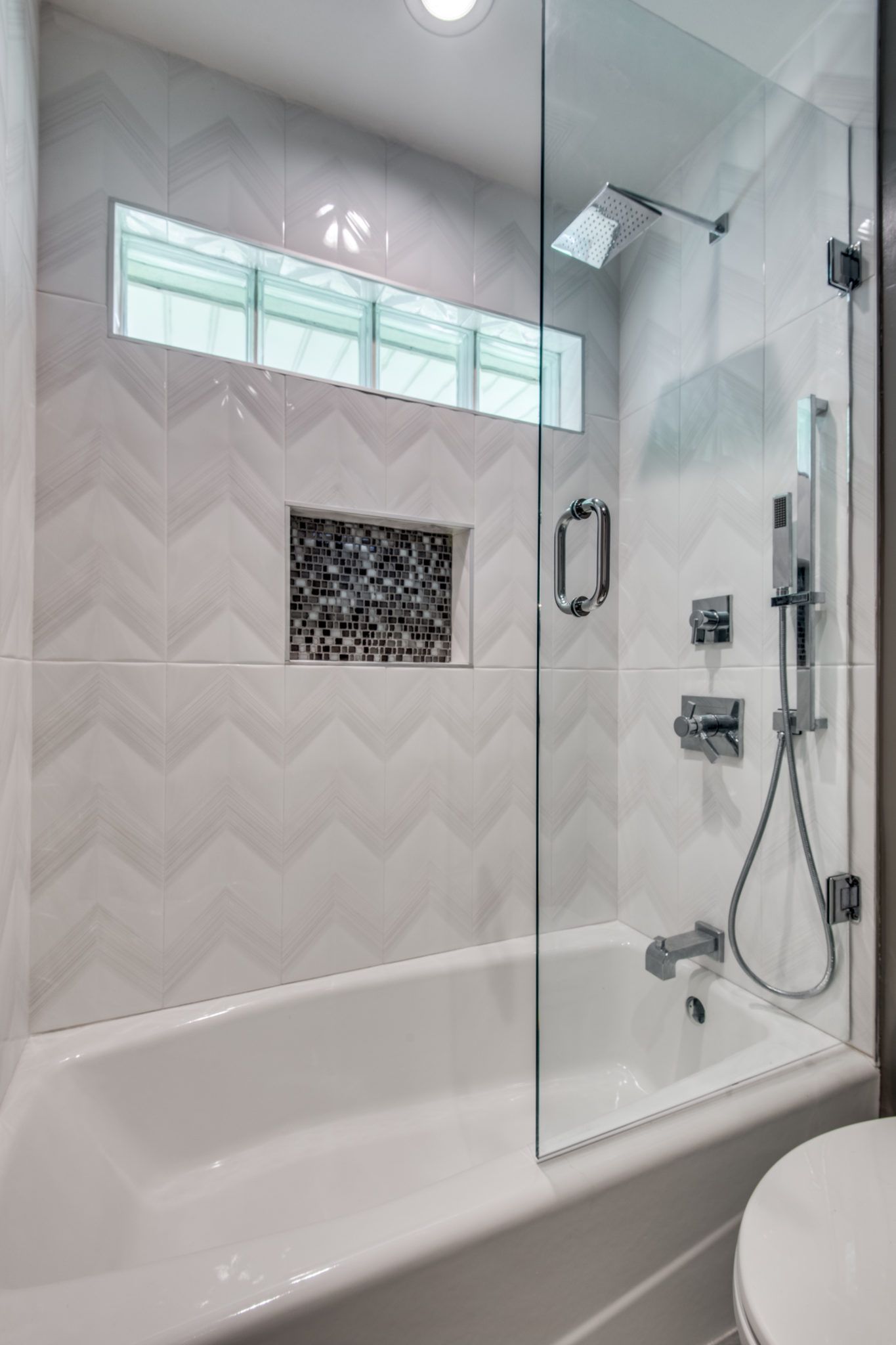 A bathroom with a bathtub and a shower with a glass door.