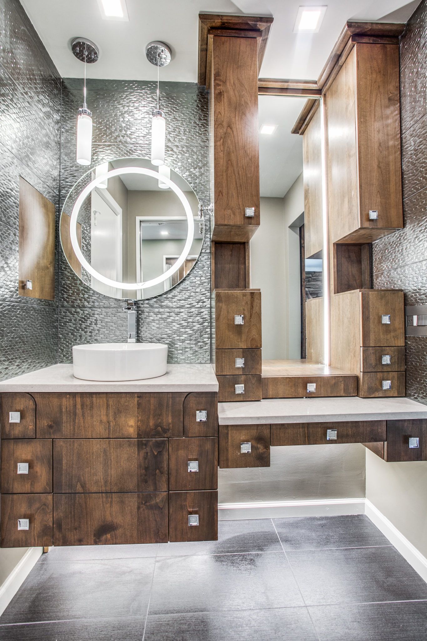 A bathroom with a sink , mirror and wooden cabinets.