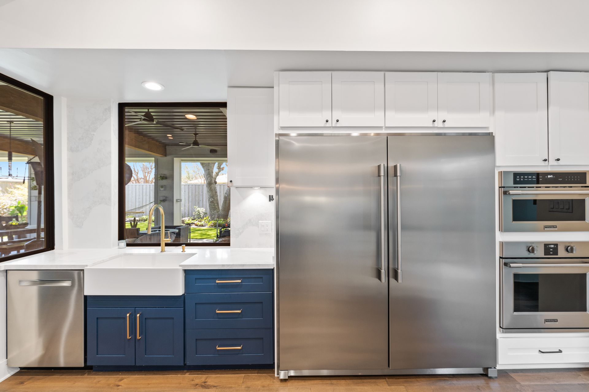 A kitchen with stainless steel appliances and blue cabinets.