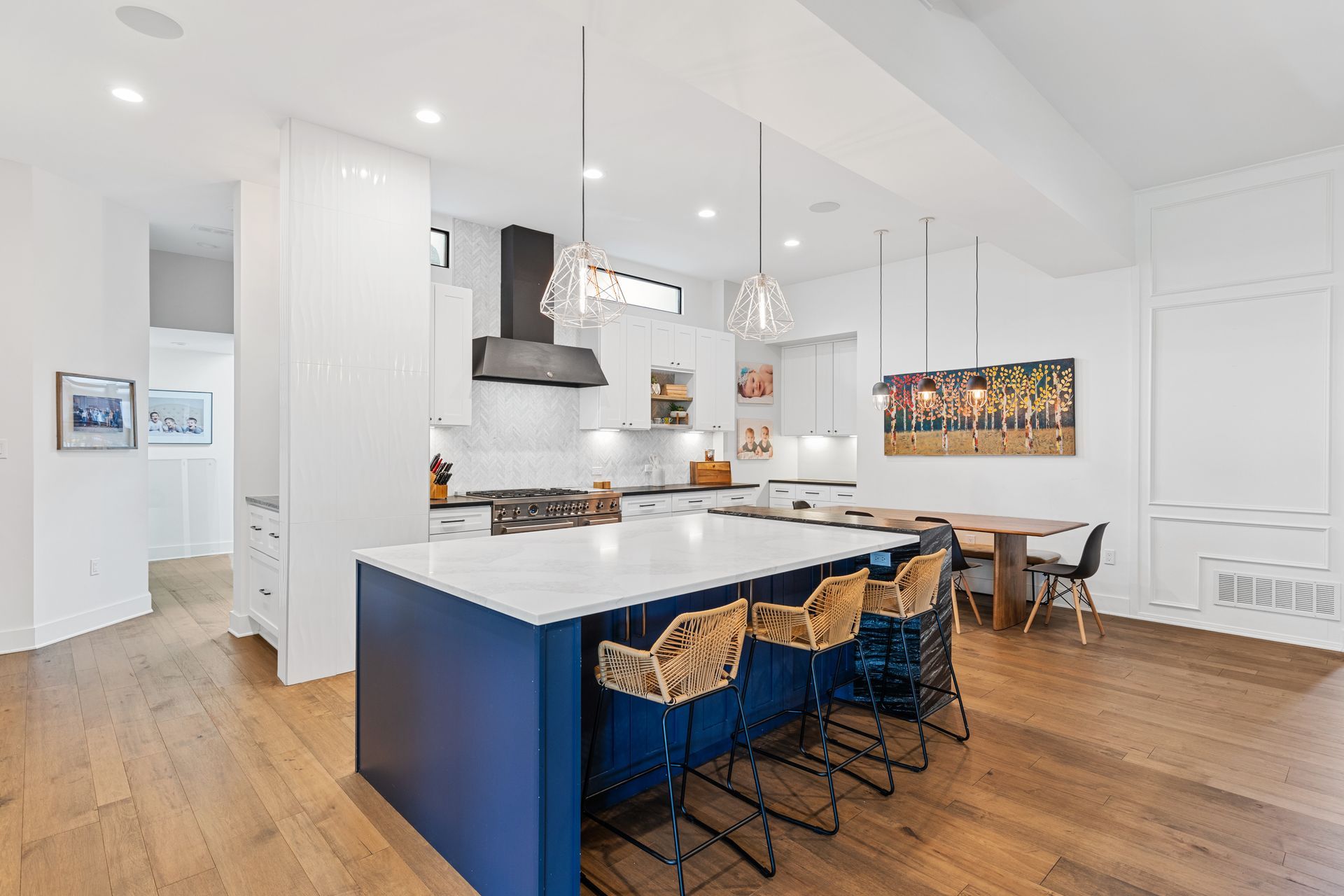 A kitchen with a blue island and white counter tops.