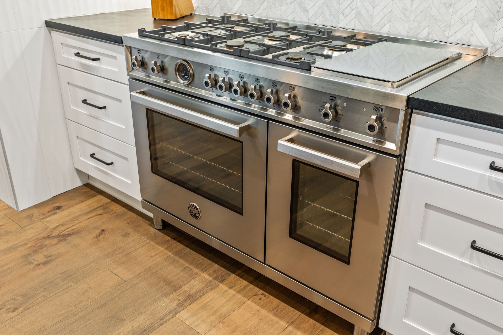 A stainless steel oven is sitting on top of a stove in a kitchen.