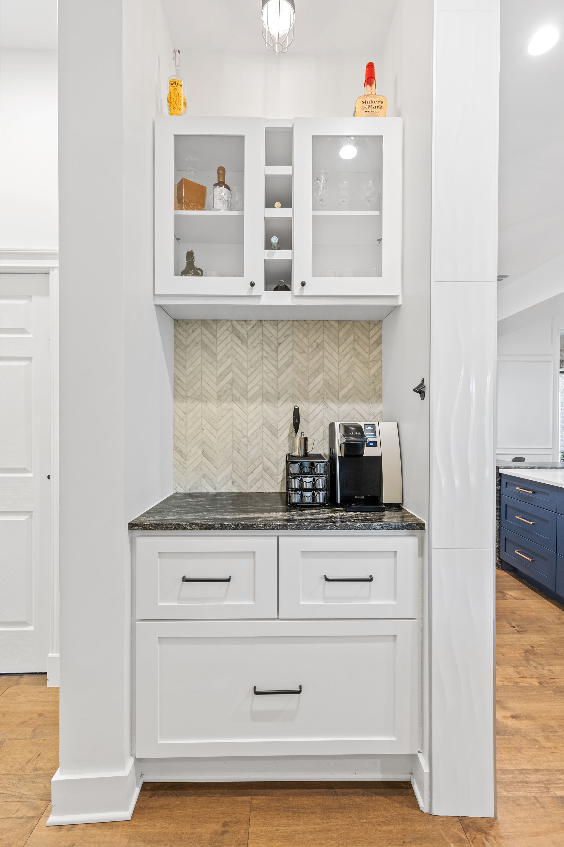 A kitchen with white cabinets and a coffee maker.