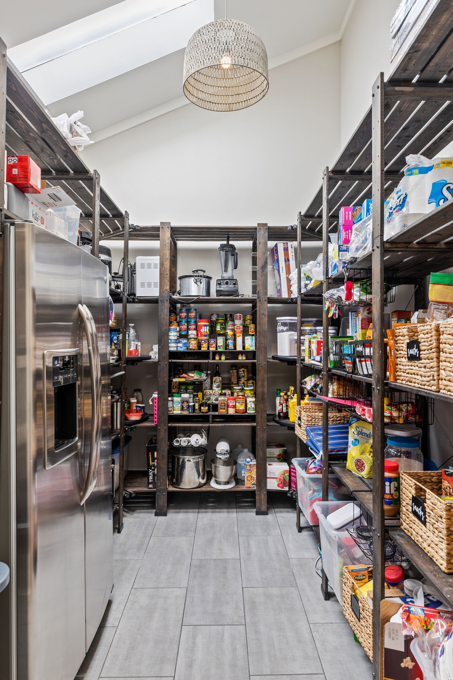 A pantry filled with lots of food and a refrigerator.
