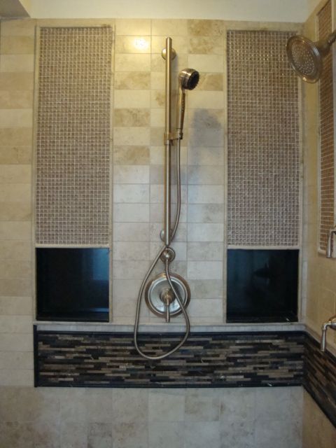 A bathroom with a stainless steel shower head