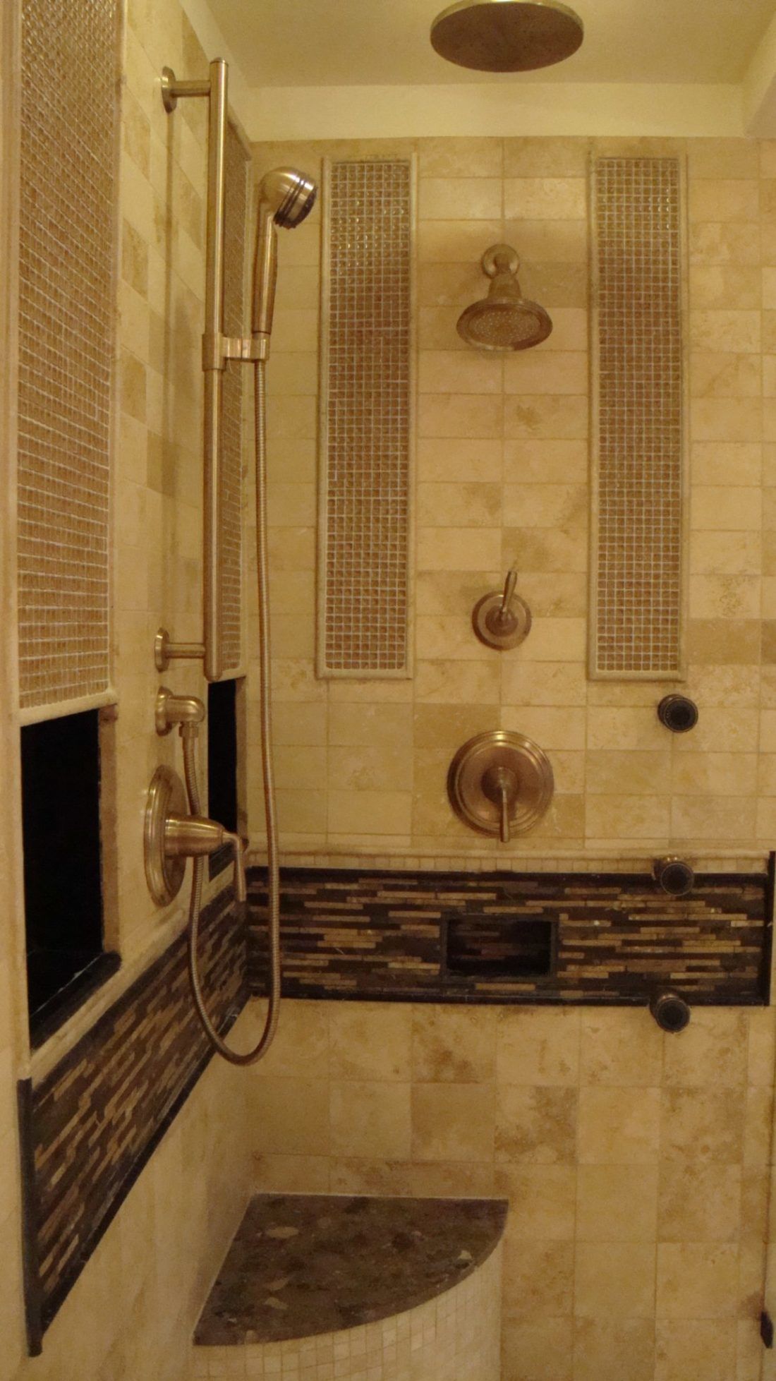 A bathroom with a walk in shower and two shower heads.