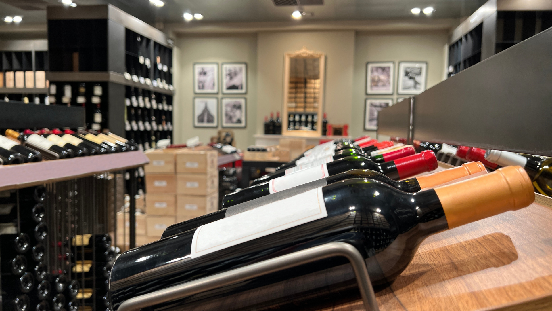 Wine bottles on display in a wine shop, with various labels and colors.