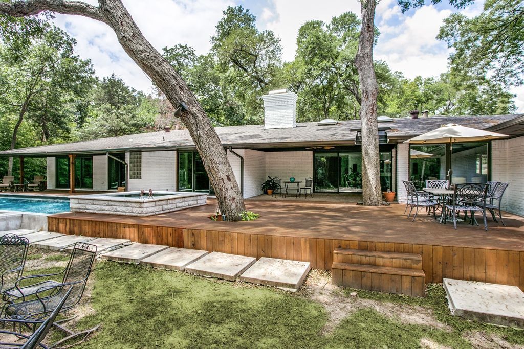 A house remodel with a large deck and a swimming pool in the backyard.