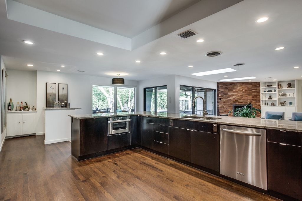 A large kitchen with stainless steel appliances and wooden floors.