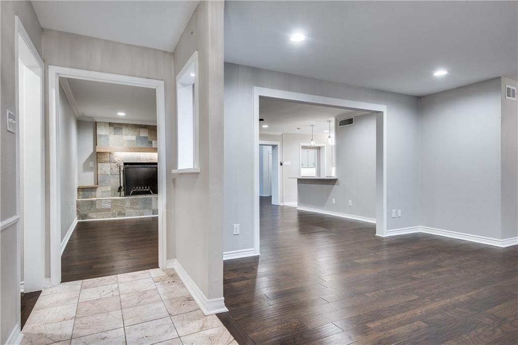 A large empty room with hardwood floors and a fireplace.