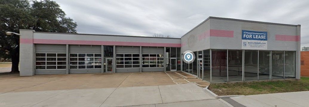 A large gray and pink building with a lot of windows and doors.