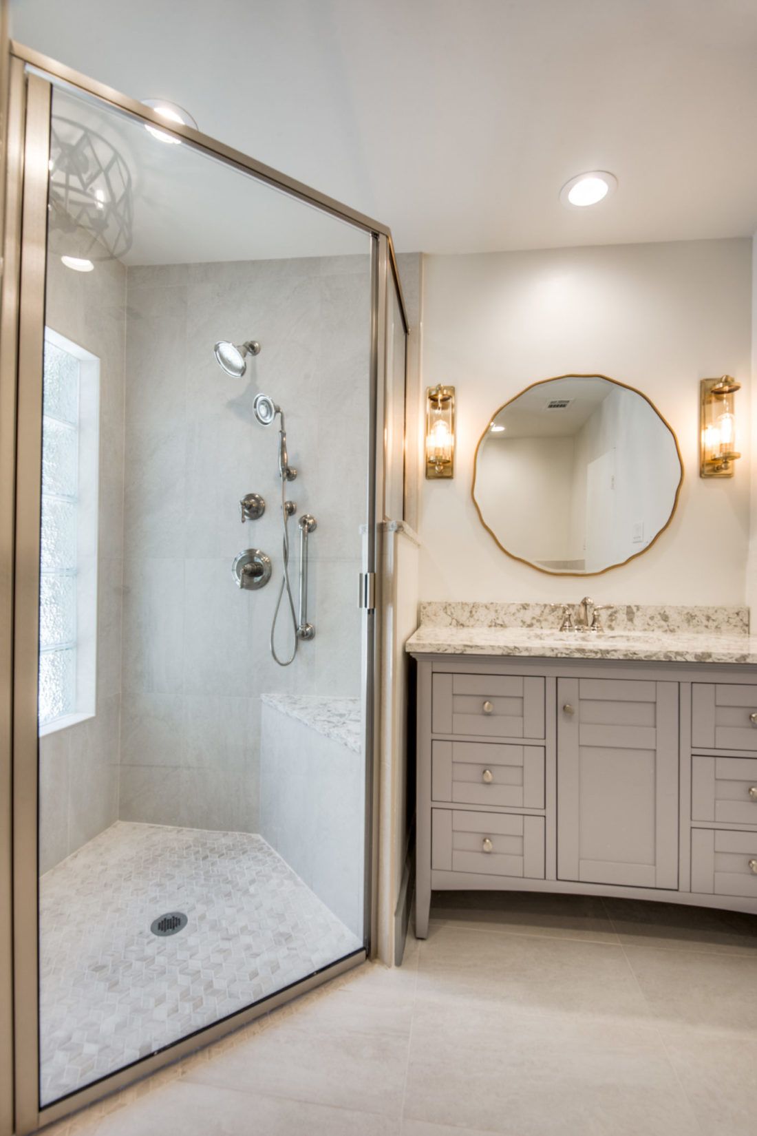A bathroom with a walk in shower , sink and mirror.