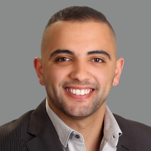 A man in a suit is smiling for the camera