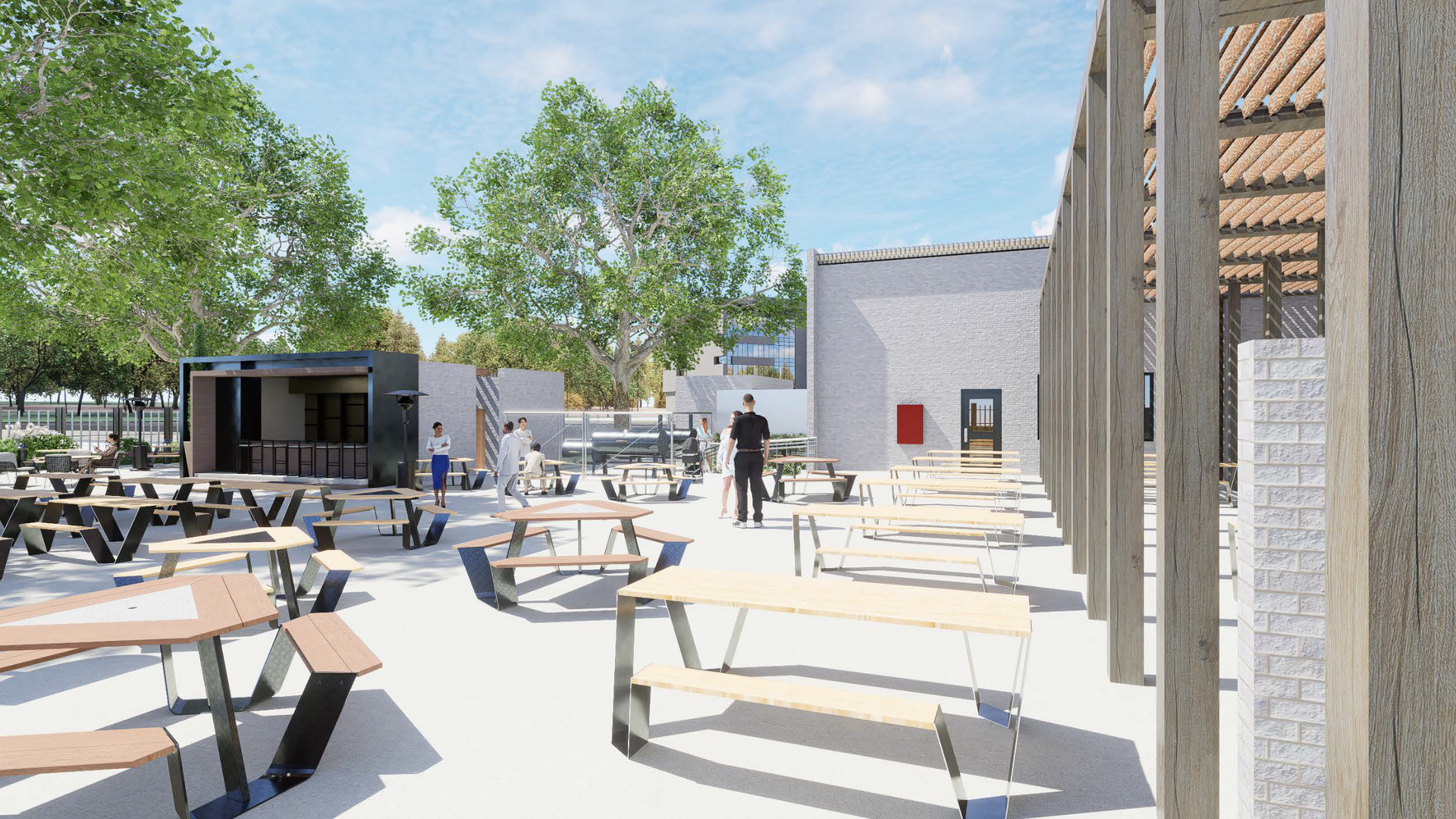 Outdoor dining area with picnic tables, food truck, and building with open doorways.