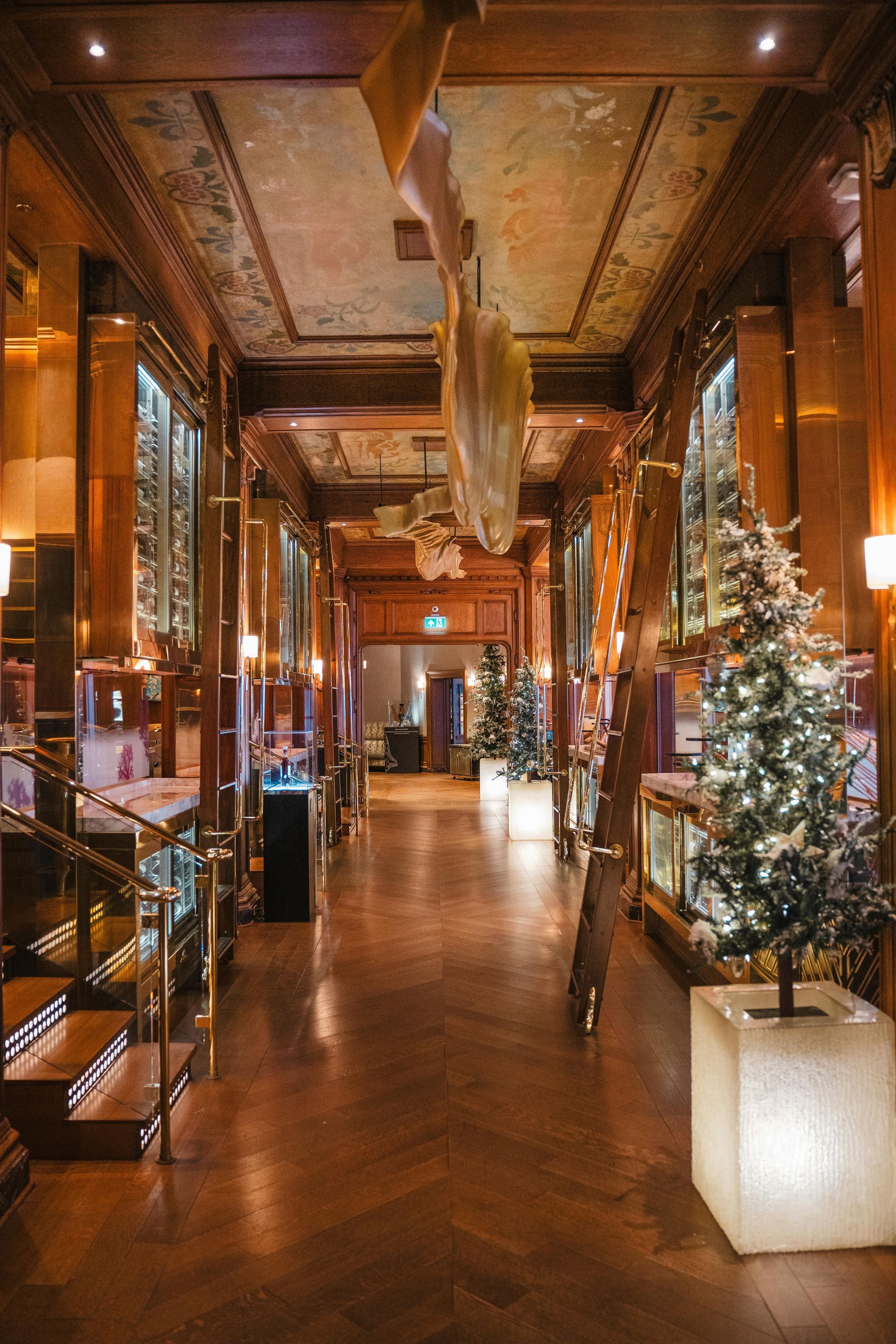 A long hallway with a christmas tree in the middle of it.
