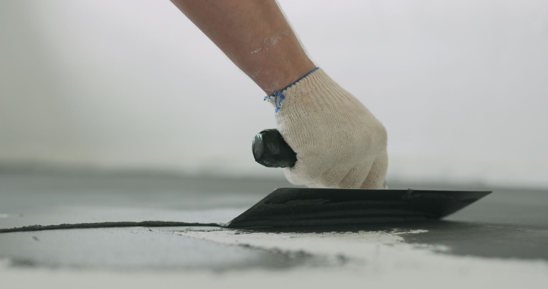 Decorative concrete contractor finishing a stamped concrete patio surface.