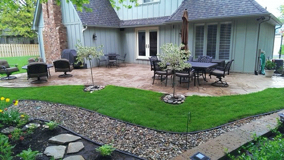 Two-story Gray House With A Raised Stone Patio