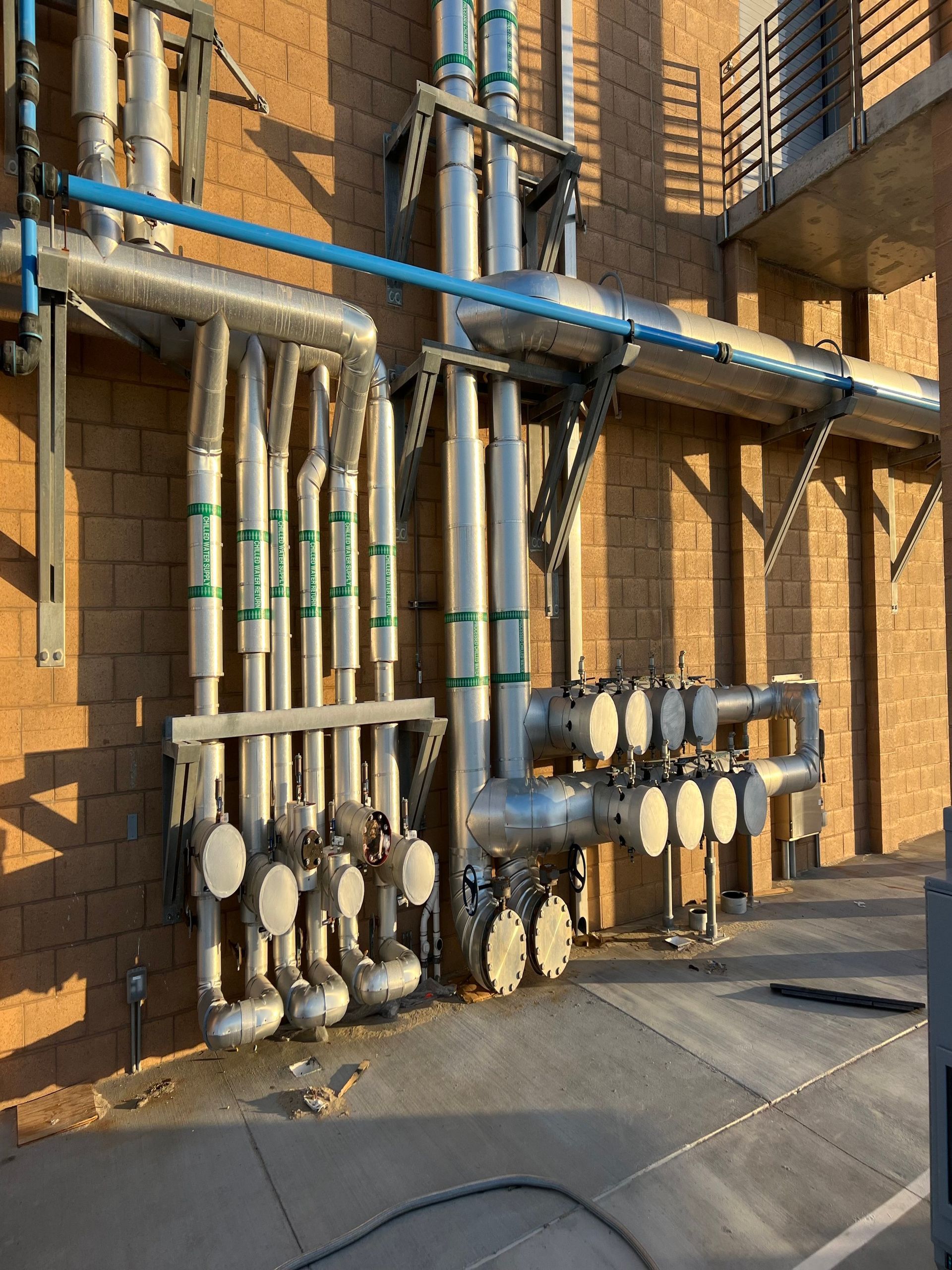 A bunch of pipes are attached to a brick wall