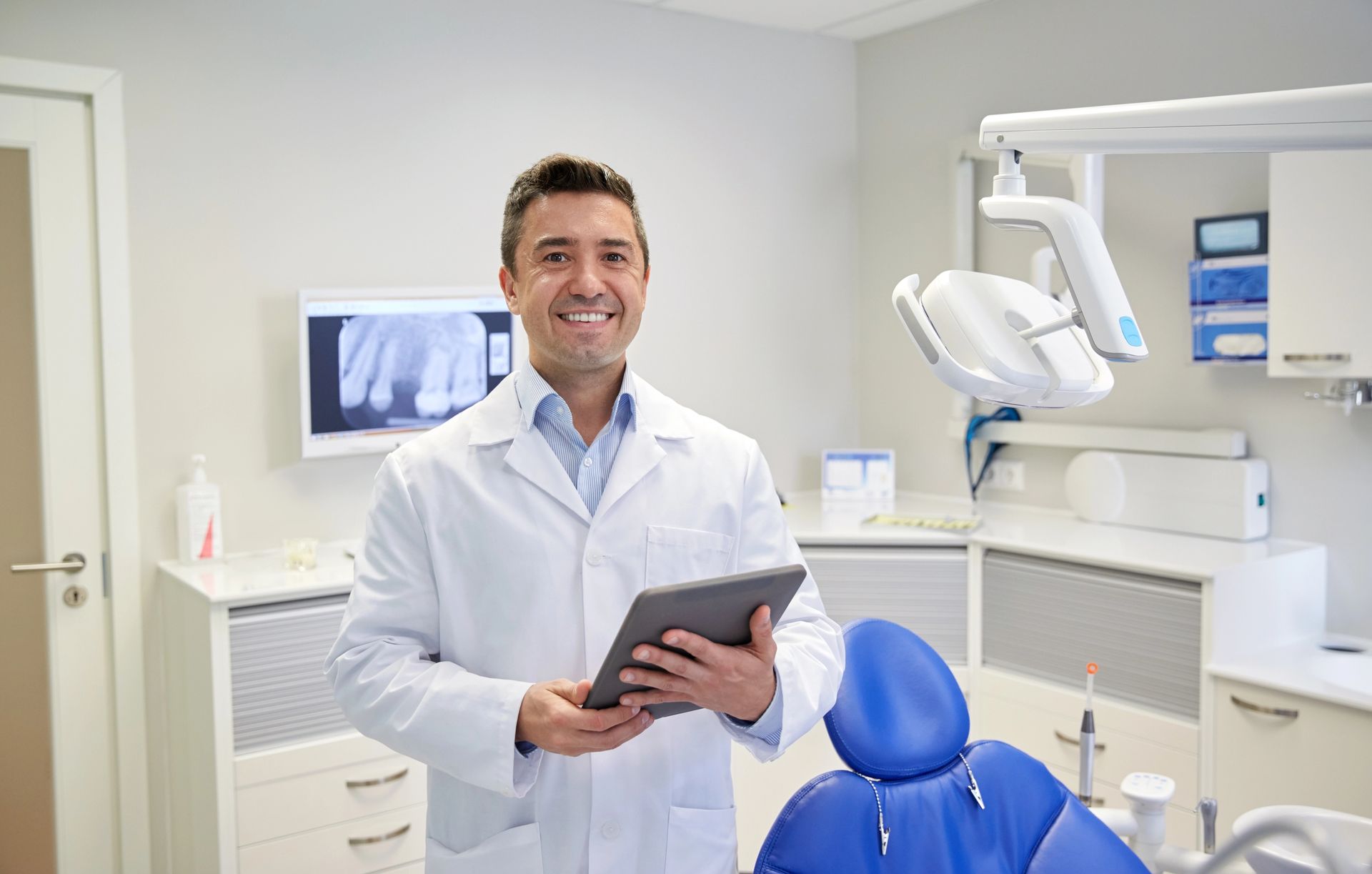 Dentist wearing lab coat as PPE.