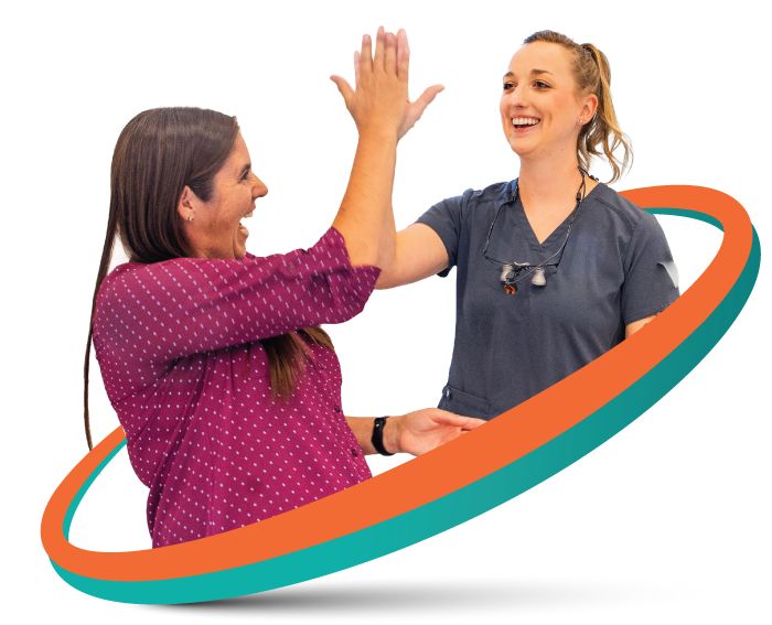 Two women high-five, smiling, with a teal and orange swoosh around them.