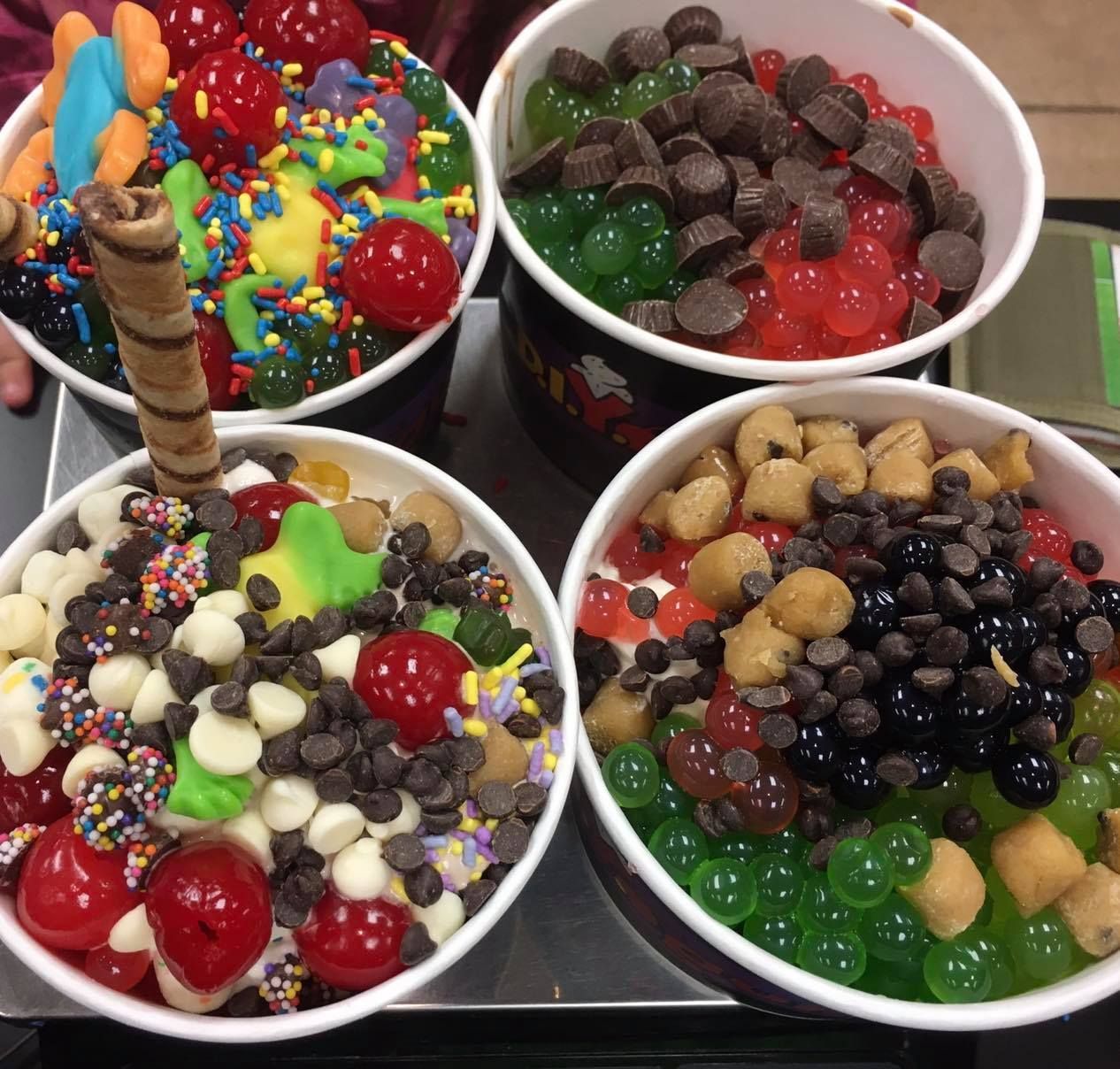 Assorted candy bowls with colorful sweets and chocolate pieces on a tray