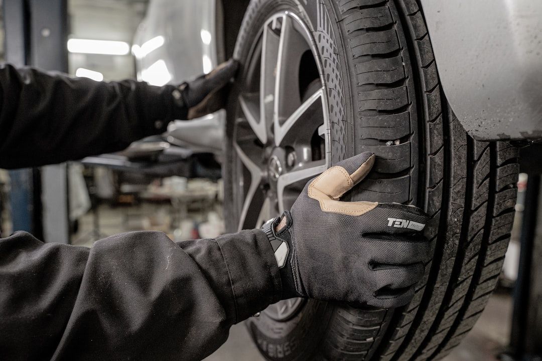Mechanic tightening a car tire in a garage with a wrench