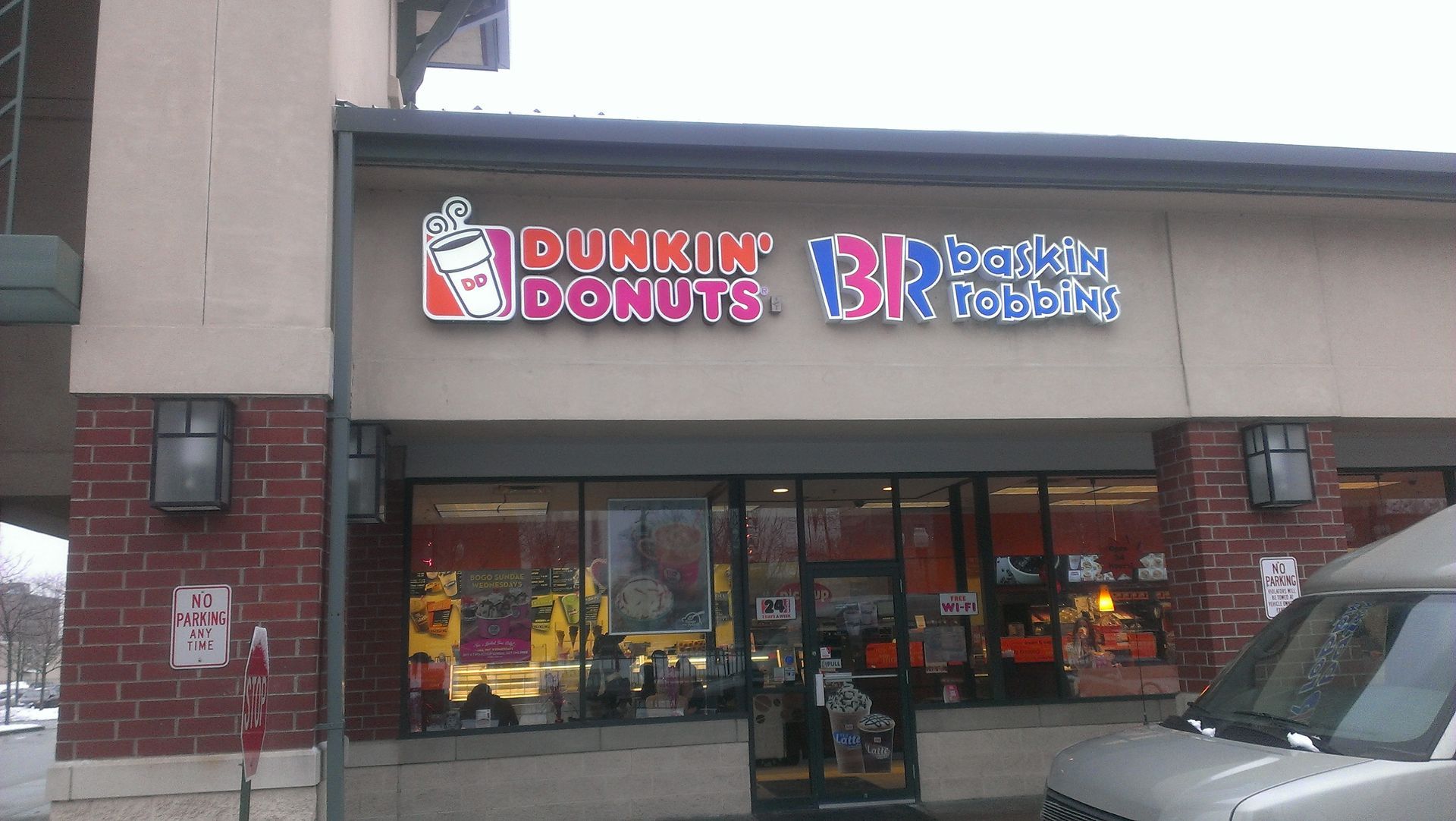 A brick-exterior storefront with Dunkin' Donuts and Baskin-Robbins signage, located under a dark brown awning.