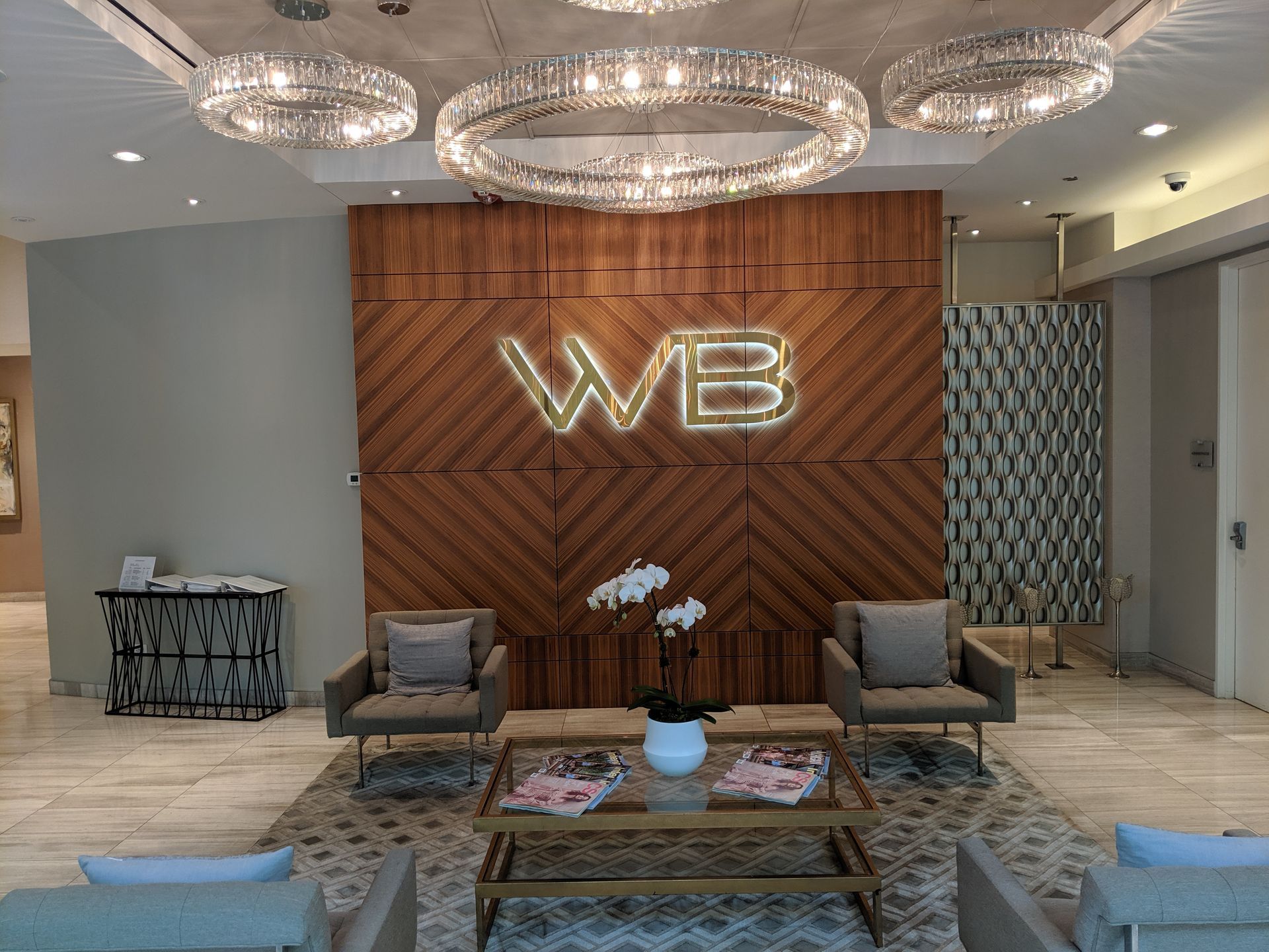 A lobby features a wooden wall with an illuminated 