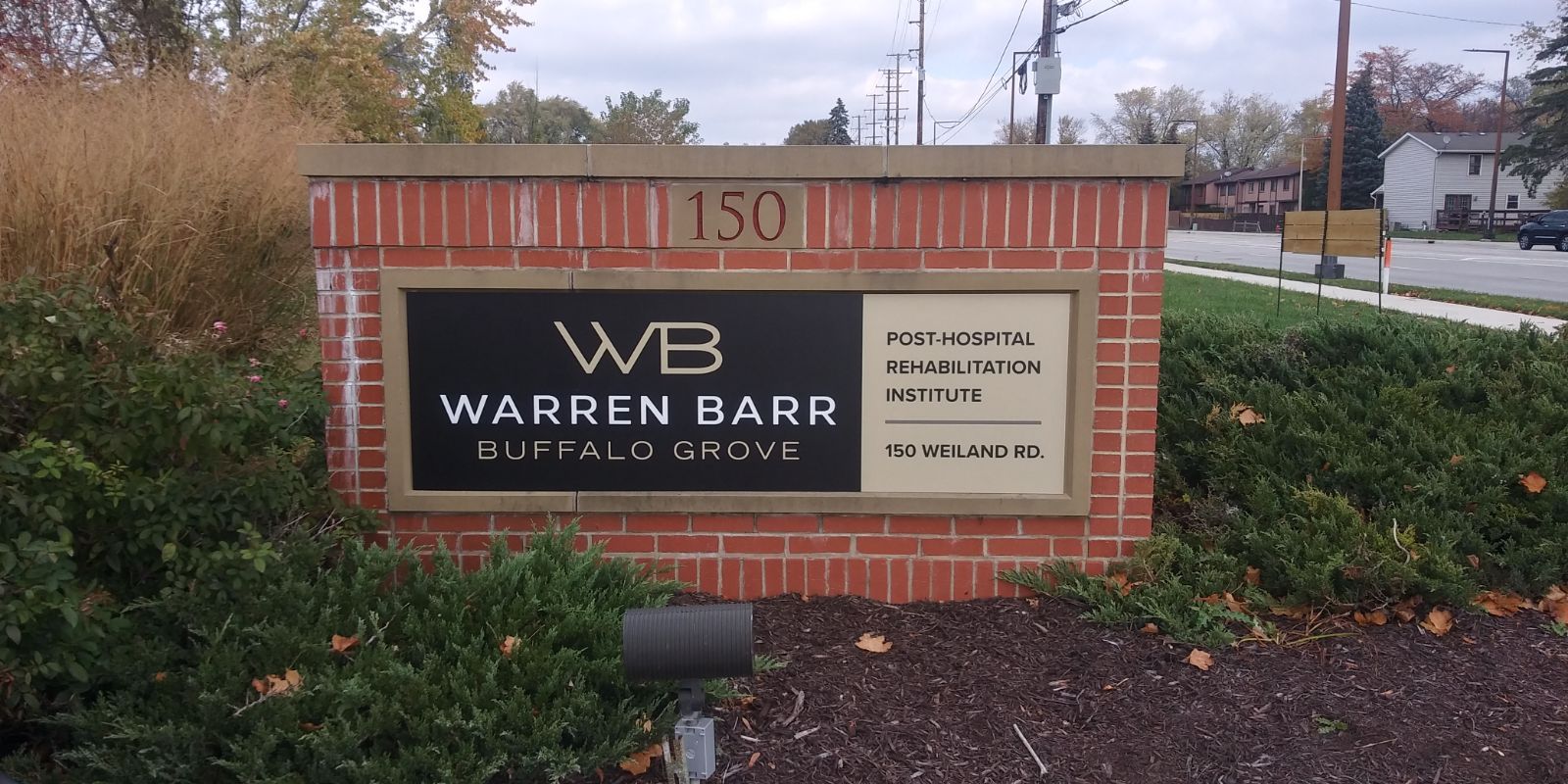 A brick monument sign for Warren Barr Buffalo Grove at 150, featuring white text on a black and beige background.
