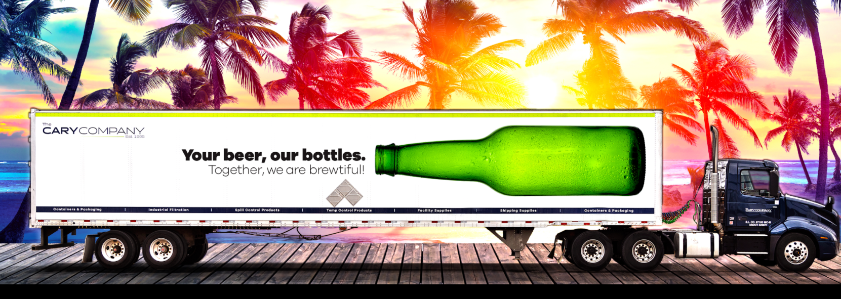 A semi-truck with a large green beer bottle graphic on its trailer, parked against a vibrant tropical sunset backdrop.